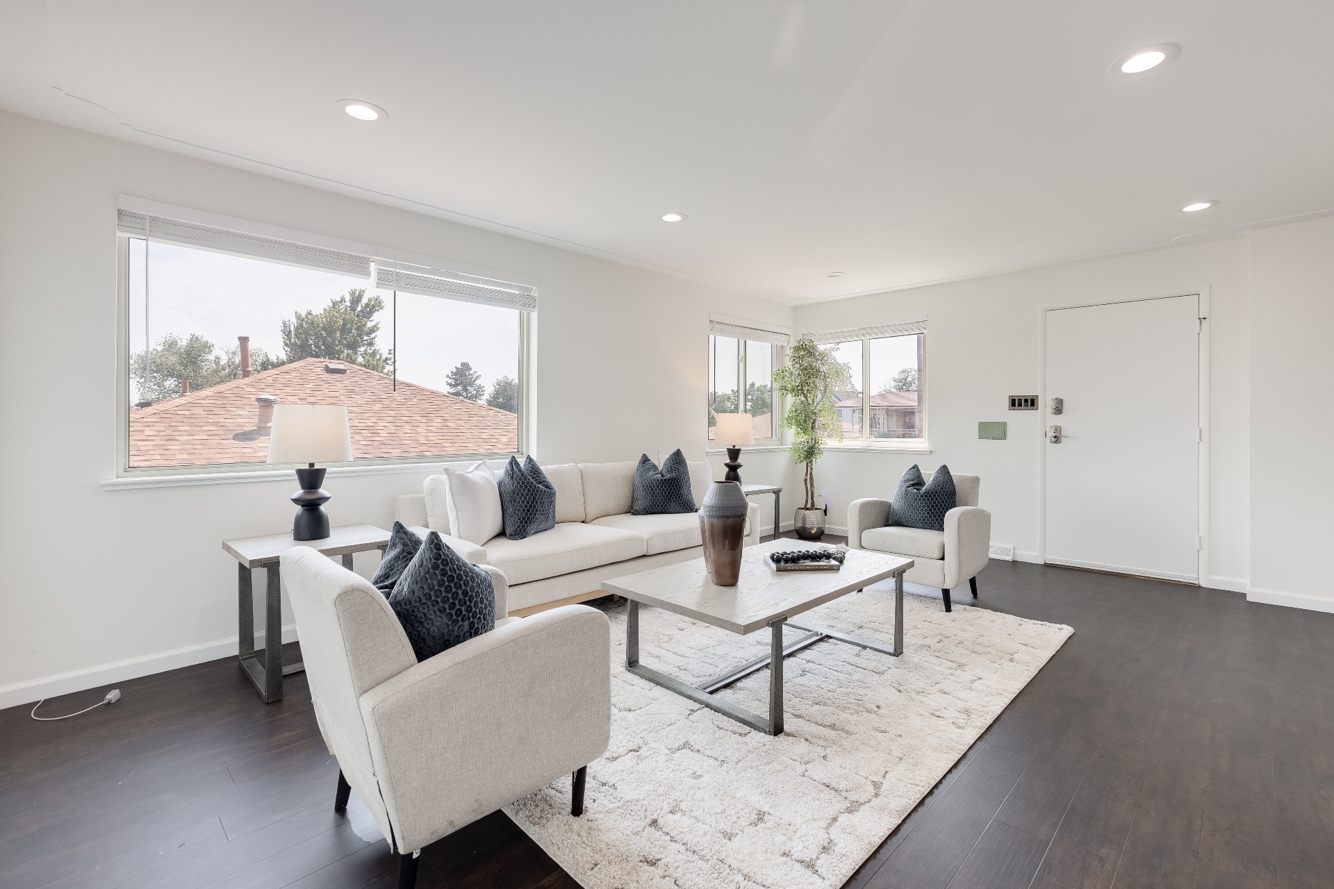 Bright open-concept living room with vaulted ceiling, neutral sectional, and mountain-view windows